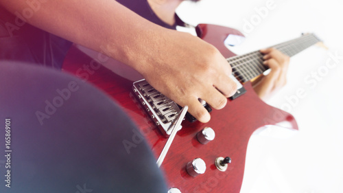 A man playing red electric guitar