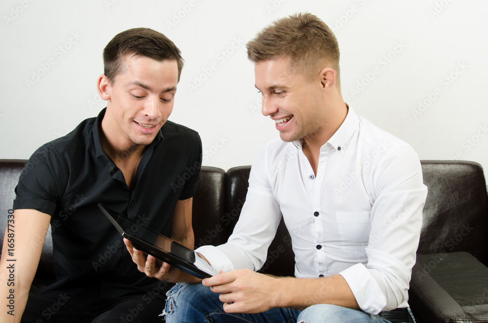 Two happy guys are working on a tablet. Two happy guys are working on a tablet.