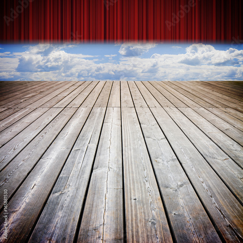 Open theater red curtains and wooden floor against a cloudy sky - concep timage photo