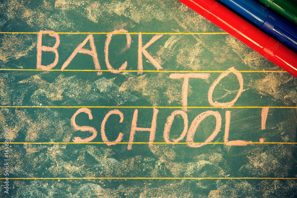 Concept Back to School. Blackboard with text back to school written with chalk