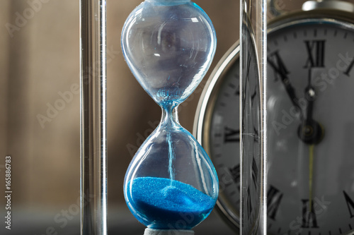 Time is passing. Blue hourglass close up