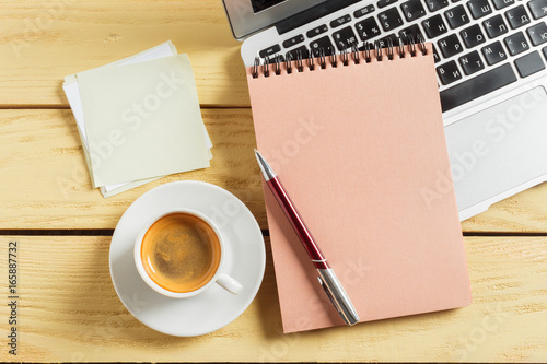 Office table background with coffee cup, pencils and computer keyboard. Business workplace or workspace concept.