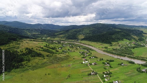 aerial view agriculture field and mountains. summer day. Summer day landscape.  Flying over the beautiful rural landscape. Aerial camera shot. 