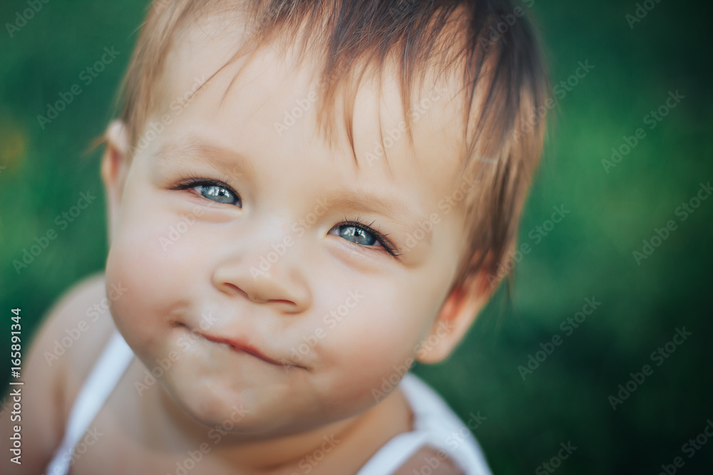 little baby girl is smiling with blue eyes on grass close up little baby girl is smiling with blue eyes on grass close up
