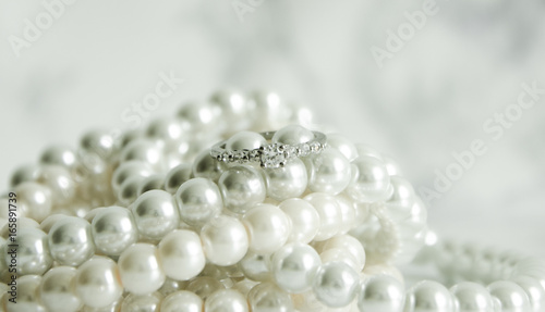 Silver ring with pearls on marble table