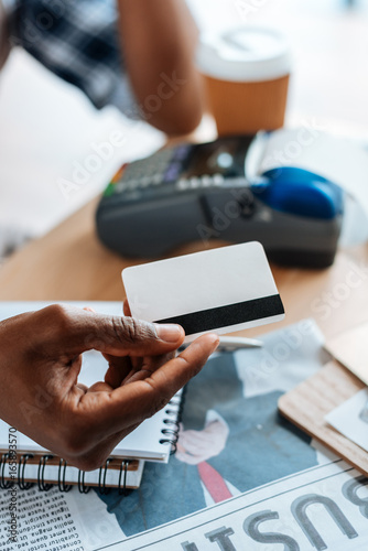 cropped view of african american man working with credit card and terminal in coffee shop