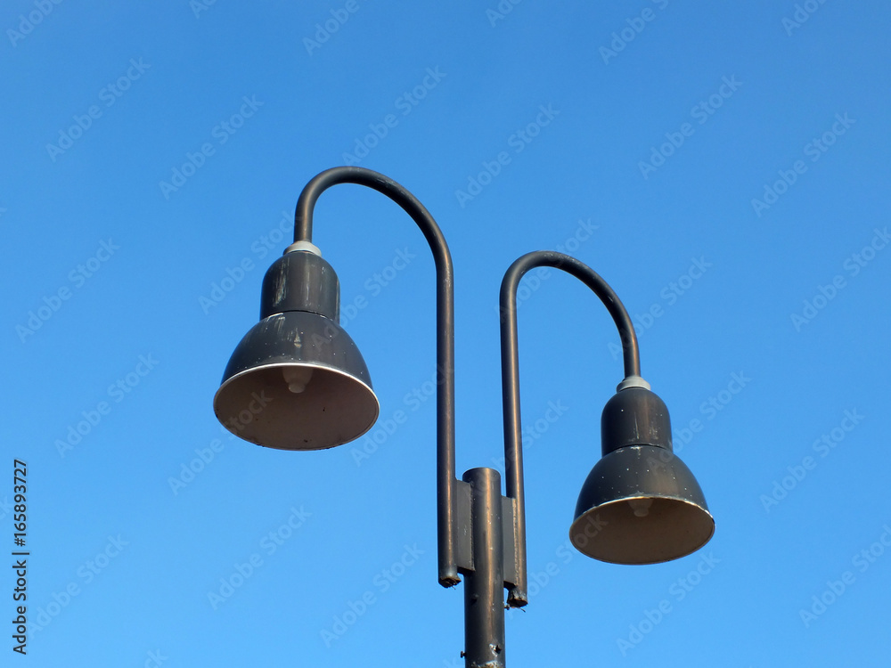 Two street lamps in the daytime against the background of clear blue sky Two street lamps in the daytime against the background of clear blue sky
