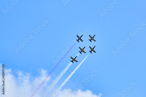 Sport planes aerobatic team vapour trails in blue sky. Plane white vapour trails tracks background. Plane aerobatic maneuver stunt. Stunt planes aerobatic team vapor trails.