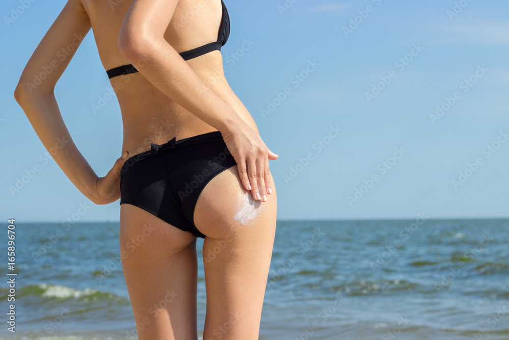 Suntan Lotion Woman Applying Sunscreen Solar Cream. Beautiful cute girl applying Sun Tan Cream on her skin on the beach. Sun Tanning. Skin care and Protection. Vacation Suntan Lotion Woman Applying Sunscreen Solar Cream. Beautiful cute girl applying Sun Tan Cream on her skin on the beach. Sun Tanning. Skin care and Protection. Vacation