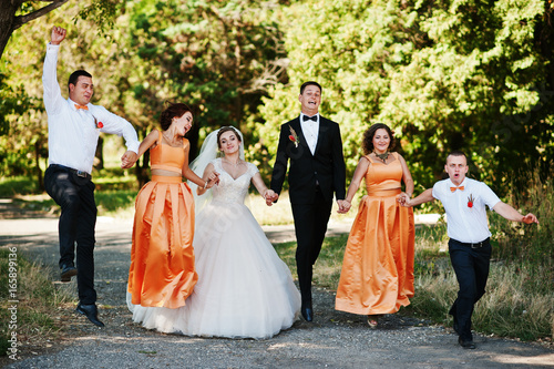 Beautiful wedding couple walking and having fun with groomsmen and bridesmaids in the park. © AS Photo Family