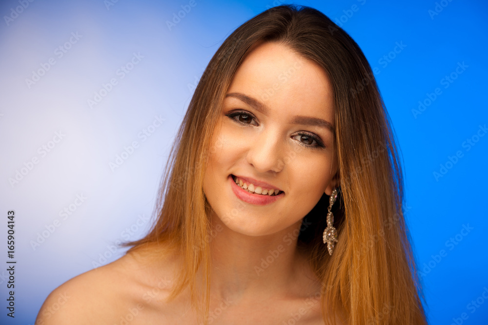 Obraz premium Beauty portrait of a cute teenage girl over blue background