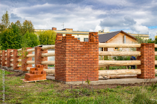Construction of a fence of bricks and wood  