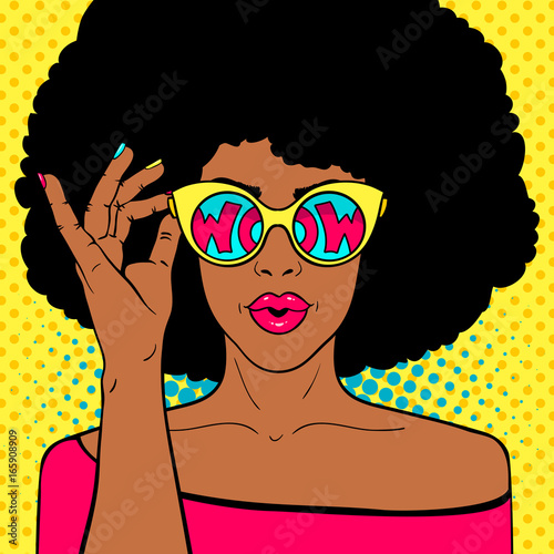 Wow pop art face. Sexy surprised black woman with afro hair and open mouth holding sunglasses in her hand with inscription wow in reflection. Vector colorful background in pop art retro comic style.