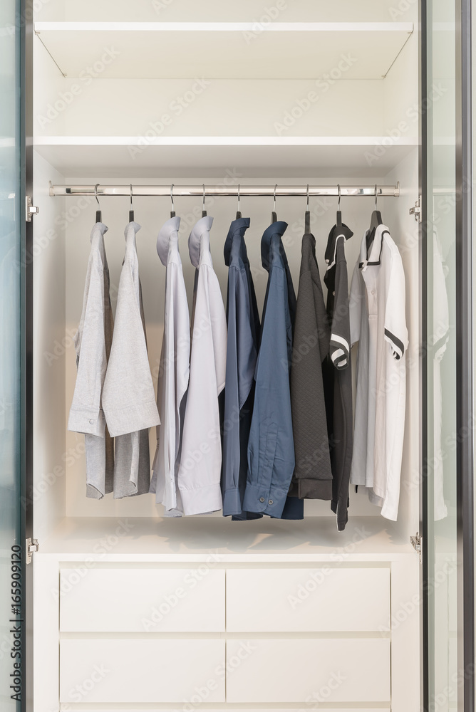 clothes hanging on rail in wooden white wardrobe clothes hanging on rail in wooden white wardrobe