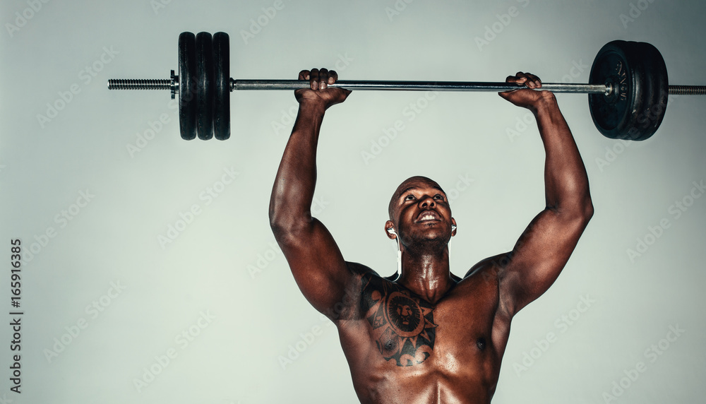 Muscular african man exercising with barbell Muscular african man exercising with barbell