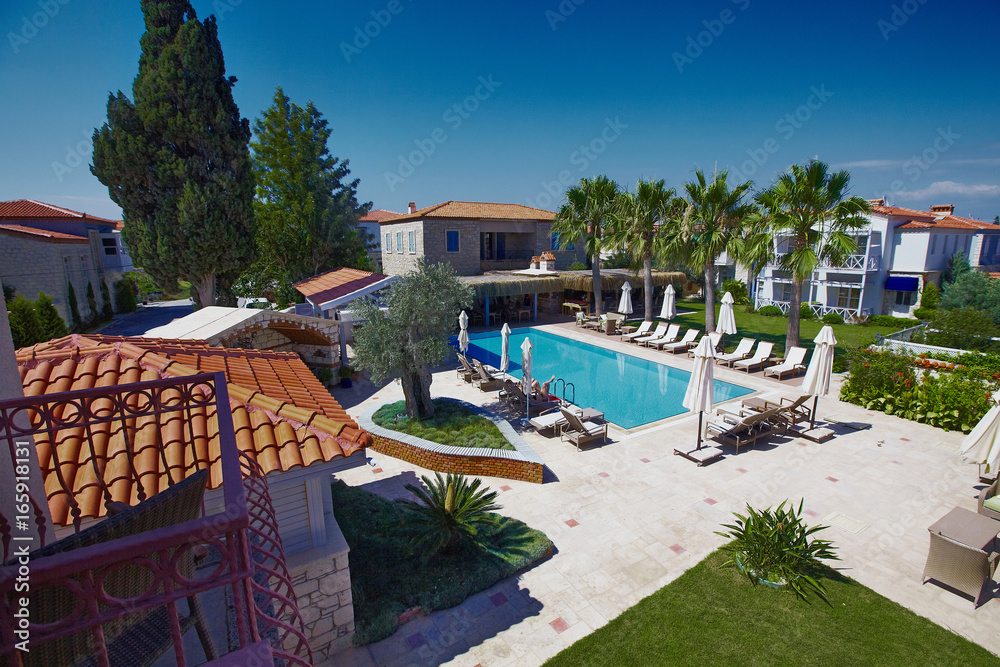 View of relaxing pool in small boutique hotel with palms and garden