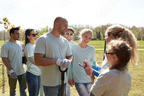 group of volunteers with tree seedlings in park