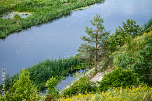 Summertime landscape - river valley of the Siverskyi (Seversky) Donets, the winding river over the meadows between hills and forests, border region of Ukraine near to Russia