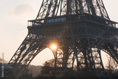 Eiffel tower close-up against sun at sunrise - Paris