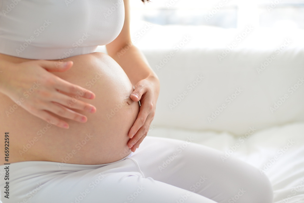 Pregnant woman with a cream tube