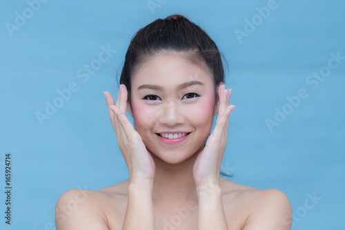 Asian beauty women smile and touching her cheek on blue background