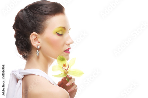 young woman with bright make up holding orchid