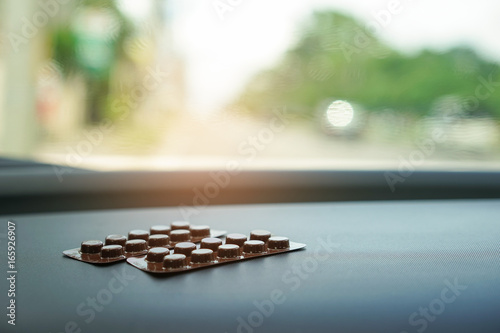 Brown blisters pack of pills on car console expose directly to sunlight.