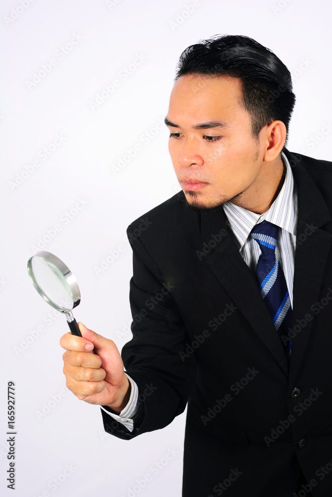 Asian Businessman looking through a magnifying glass isolated on white.jpg Asian Businessman looking through a magnifying glass isolated on white.jpg