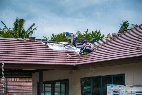 Workers are tiling new roof tiles.