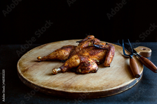 Close-up of roasted spatchcocked chicken on cutting board photo