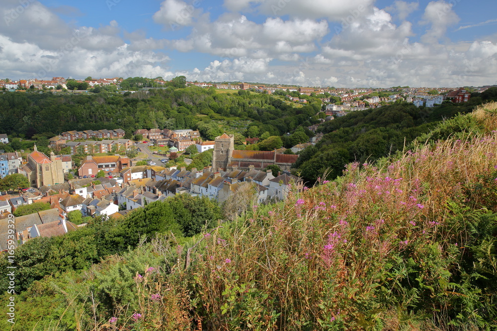 View of Hastings old town from East Hill with All Saints Church and green hills, Hastings, UK