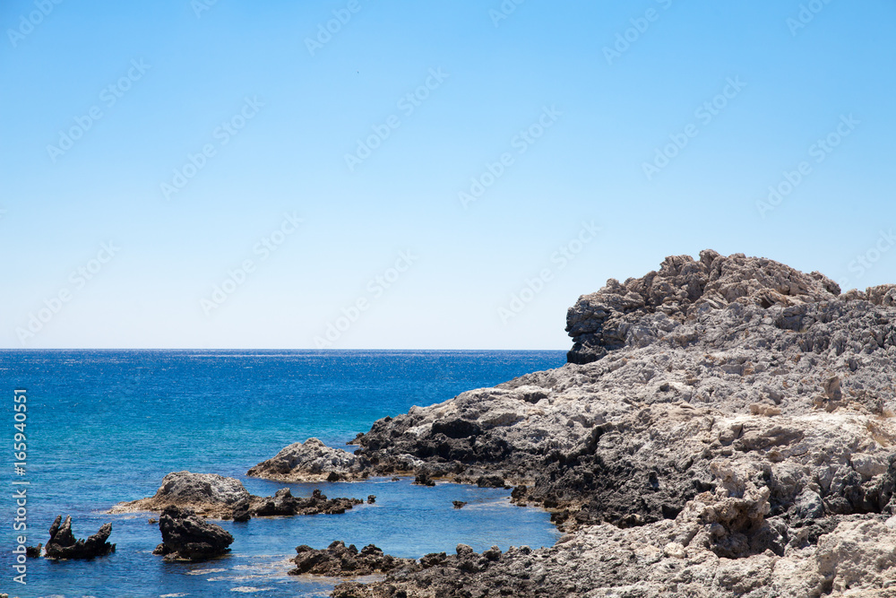 Beach off the coast of the island of Rhodes in Greece. Seaside landscape. Rocky coast and sea.