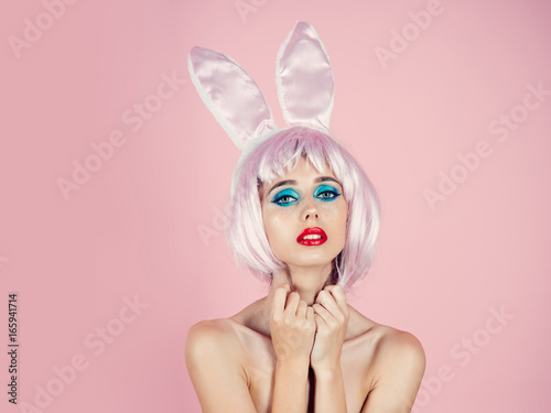 Girl with bright artificial hair and rabbit ears.