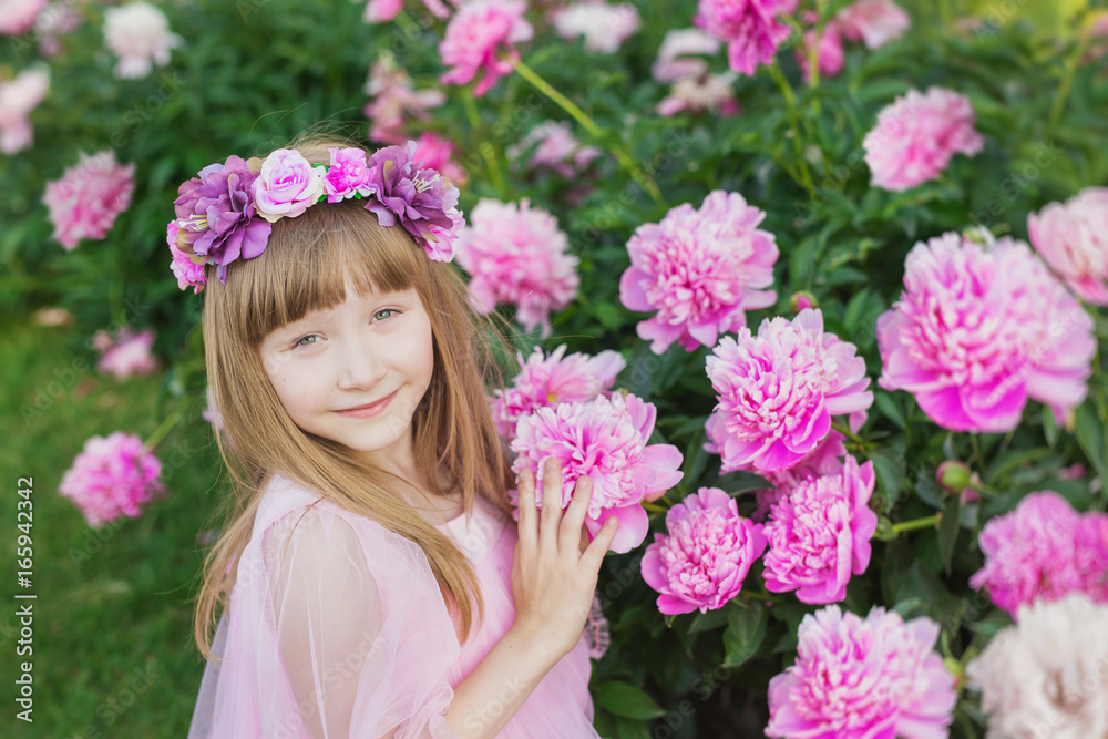 Portrait of pretty little girl in a pink dress on a pink peonies background Portrait of pretty little girl in a pink dress on a pink peonies background