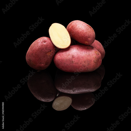 Pile of red potatoes isolated on black