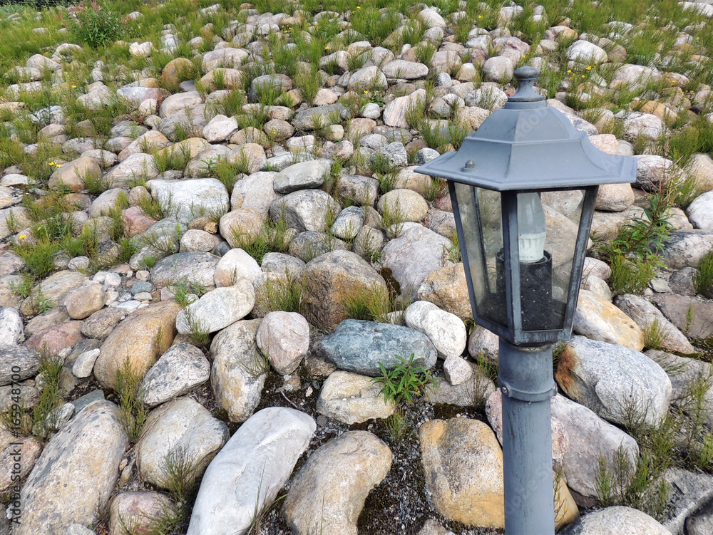 Garden lantern on background of decorative rock embankment Garden lantern on background of decorative rock embankment