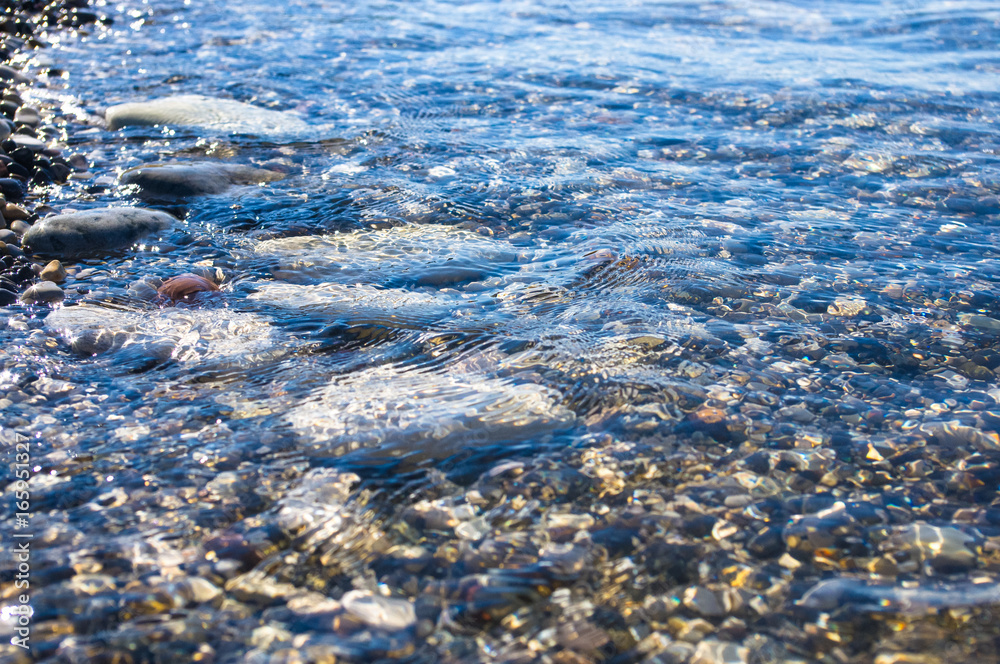 sea pebble beach with multicoloured stones, waves with foam sea pebble beach with multicoloured stones, waves with foam