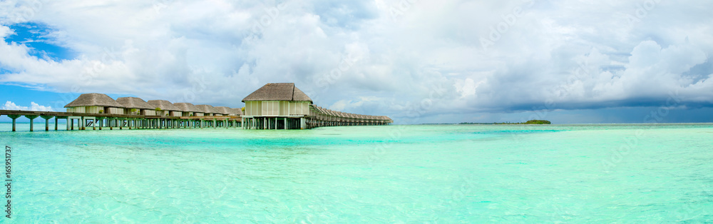 Panoramic landscape of Maldives beach with overwater bungalow