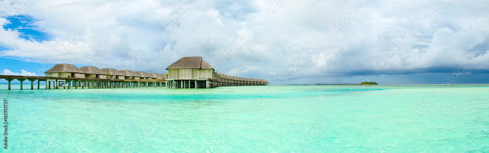 Panoramic landscape of Maldives beach with overwater bungalow Panoramic landscape of Maldives beach with overwater bungalow