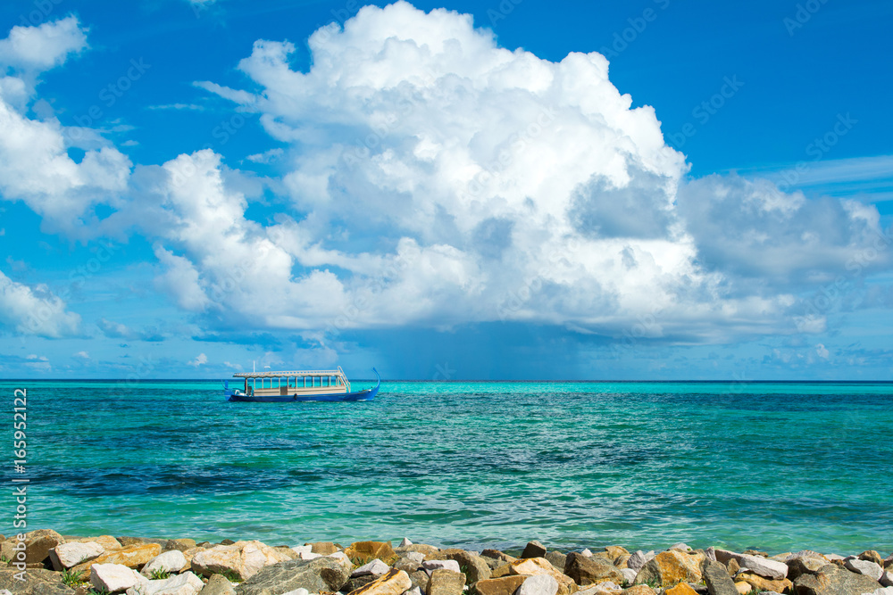 Fototapeta premium Wooden Maldivian traditional dhoni boat at sunny day on the turquoise Indian ocean water, Maldives