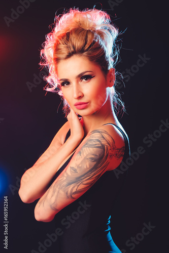 Beautiful female model posing at studio in the light flashes