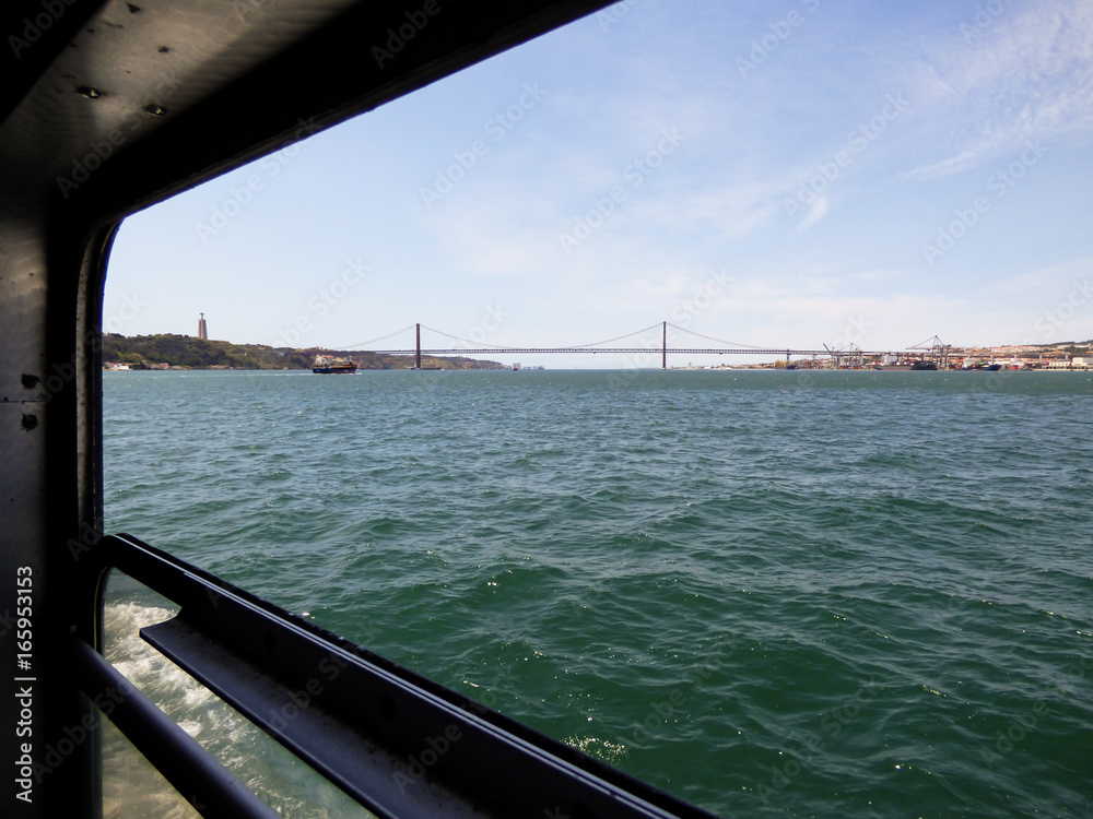 Lisbon's cityscape viewed from a ferry boat window in river Tagus