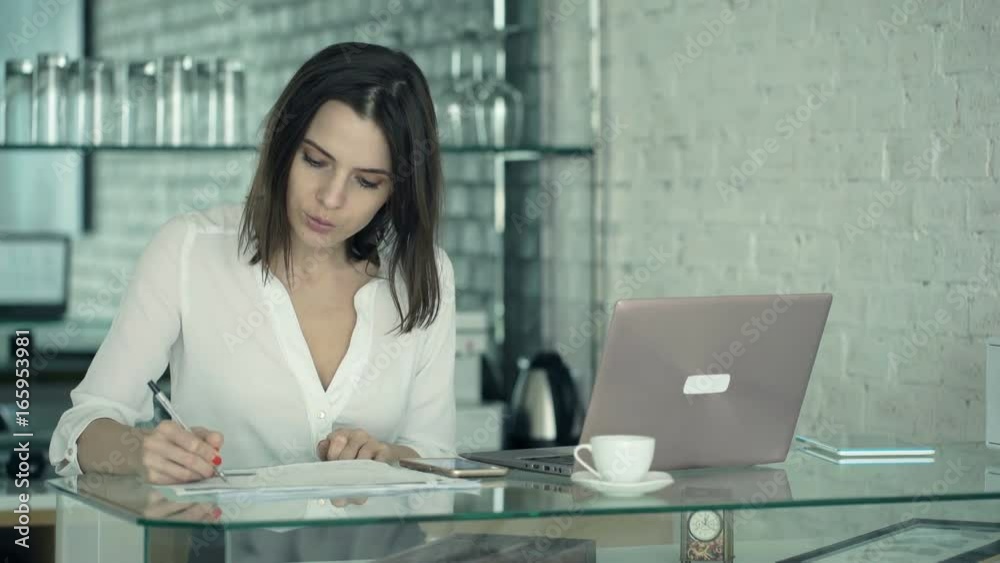 Busy, multitasking businesswoman working by table in kitchen at home
Busy, multitasking businesswoman working by table in kitchen at home
