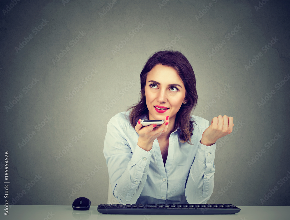 Fototapeta premium Woman using a smart phone voice recognition function on line sitting at table