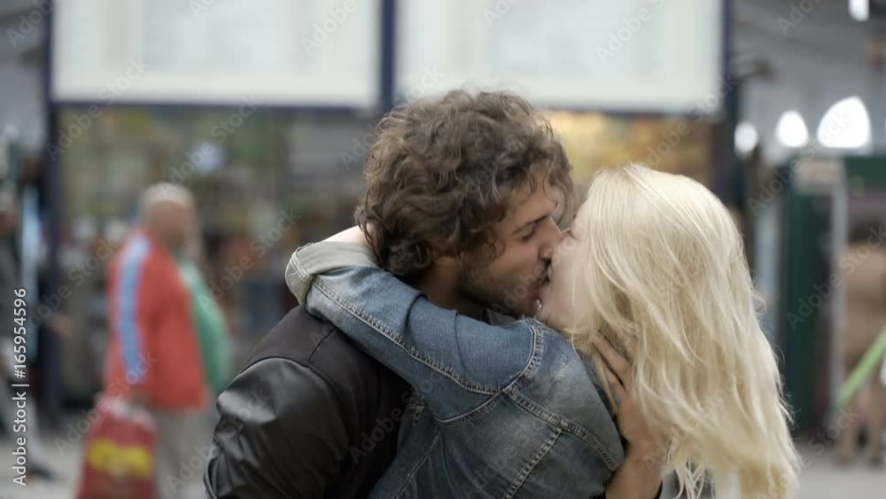 Reunited couple with young girl running to meet boyfriend kissing and hugging for reunion in airport train station Reunited couple with young girl running to meet boyfriend kissing and hugging for reunion in airport train station