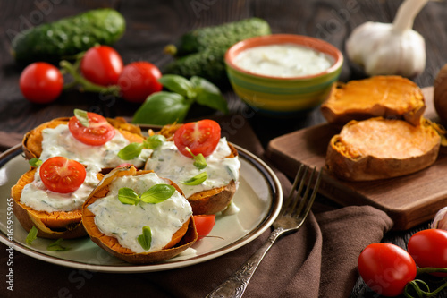 Baked sweet potatoes served with tzatziki dip.