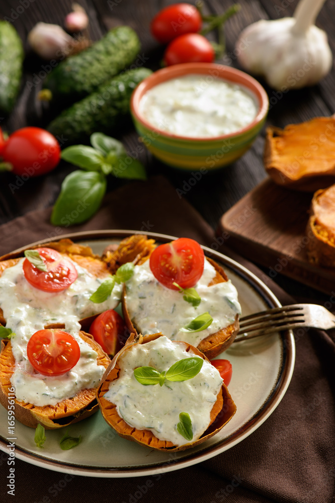 Baked sweet potatoes served with tzatziki dip. Baked sweet potatoes served with tzatziki dip.