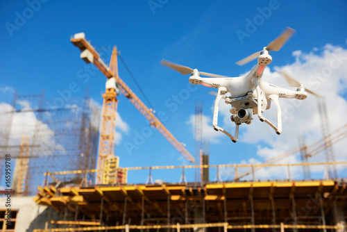 Drone over construction site. video surveillance or industrial inspection photo