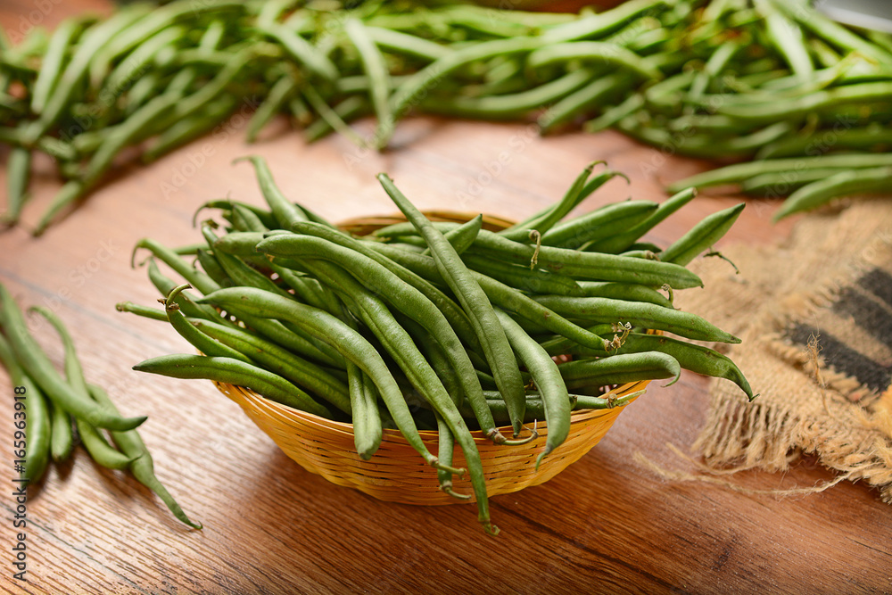 Pile of green beans on wooden table Pile of green beans on wooden table