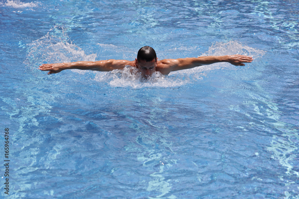 Sporty, athletic man, strong, muscular body swimming in pool style.